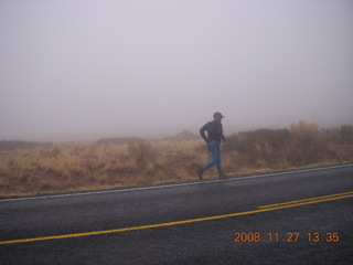 928 6pt. Canyonlands National Park - Lathrop trail hike - Adam running on the road in the rain