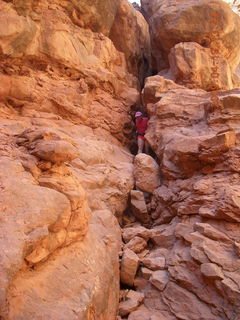 1013 6uk. Arches National Park - Adam squeezing through Squeeze Through Arch - Fiery Furnace hike