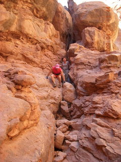 1014 6uk. Arches National Park - Adam squeezing through Squeeze Through Arch - Fiery Furnace hike