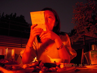143 6xs. China eclipse - Sonia reading menu at restaurant (low light)