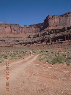 32 774. Canyonlands Lathrop Trail hike - Adam running on white rim road - back