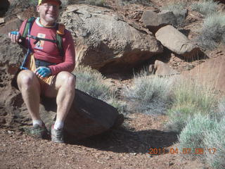 1404 7j7. Canyonlands Lathrop hike - Adam sitting on neat rock (tripod)