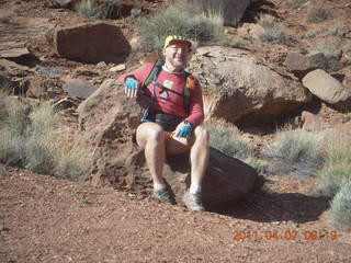 1406 7j7. Canyonlands Lathrop hike - Adam sitting on neat rock (tripod)