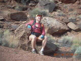 1407 7j7. Canyonlands Lathrop hike - Adam sitting on neat rock (tripod)
