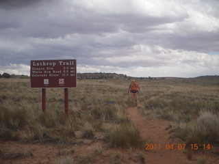 1426 7j7. Canyonlands Lathrop hike/run - Adam running with sign