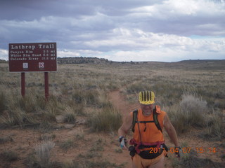 1428 7j7. Canyonlands Lathrop hike/run - Adam running with sign