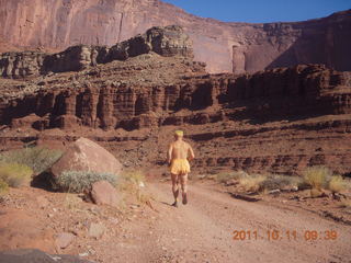 86 7qb. Canyonlands National Park - Lathrop trail hike - Adam running - back (tripod)