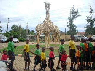 Uganda - Entebbe - Uganda Wildlife Education Center (UWEC) - school children and giraffe sculpture