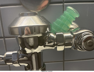 bathroom - water holder behind urinal pipes