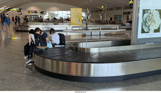 35 a2y. Spain - barcelona to bilbao flight - people sitting on baggage-claim belt