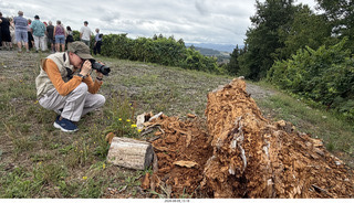 143 a2y. Spain - Bilbao wine tour - winery - guy taking picture of old log